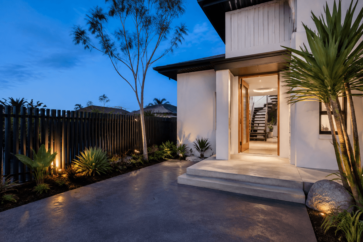 Concrete entrance, wide steps and adjoining hardscape at dusk